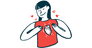 A woman smiles while gesturing with two hands toward the image of a human heart on her red sleeveless shirt.