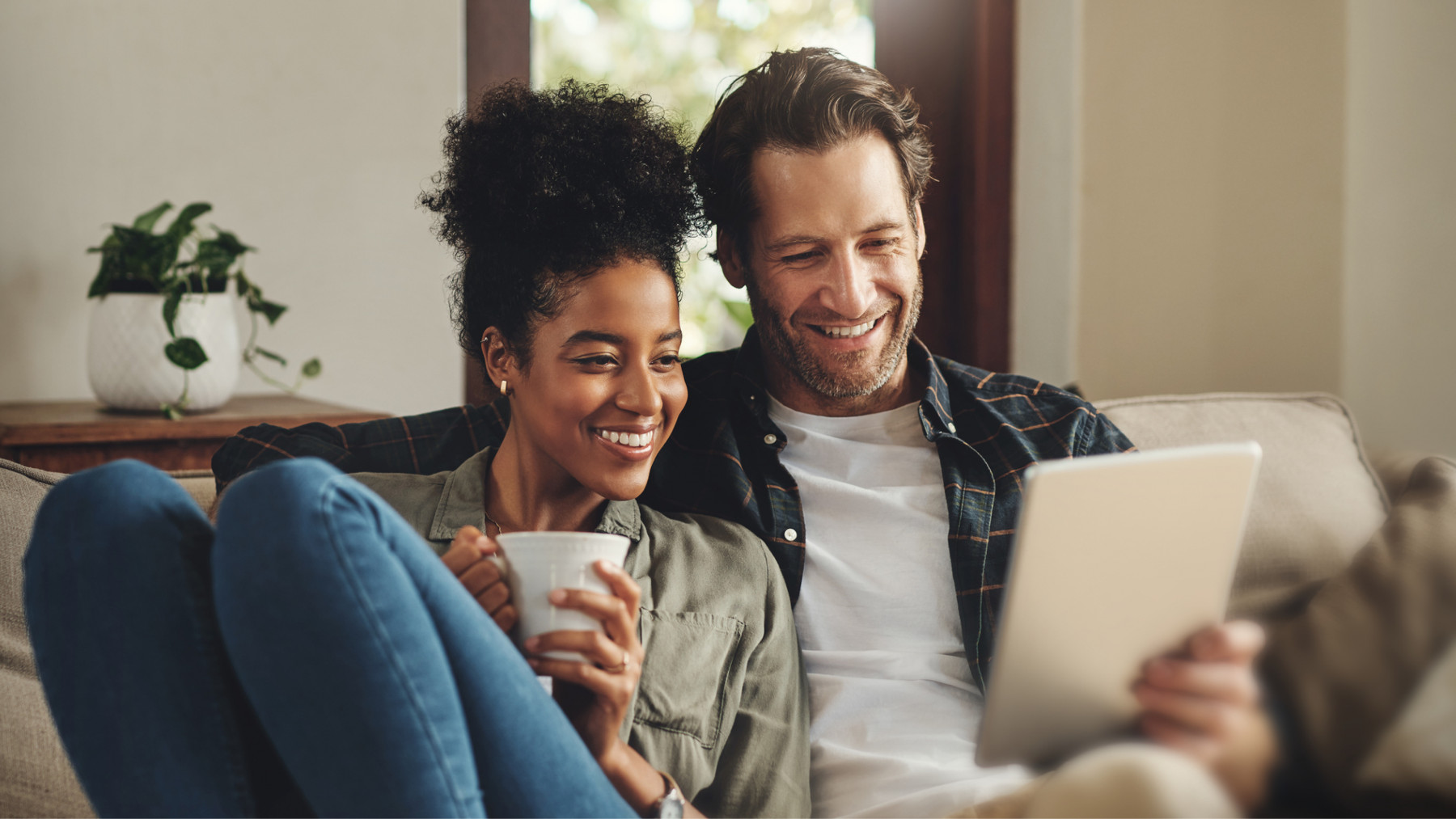 Woman and man sitting close looking at tablet