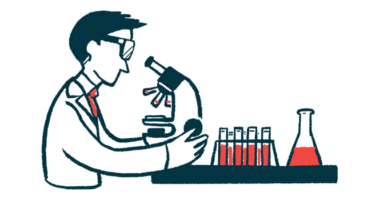 A scientist looks at samples through a microscope in a lab, with vials on the countertop nearby.