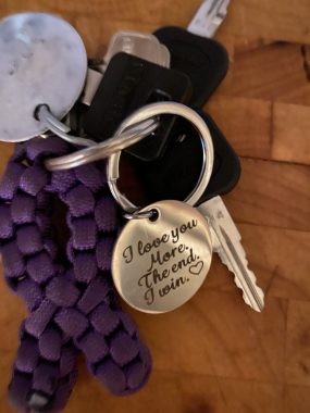 death of a friend | Pulmonary Hypertension News | a photo of a keychain with a round disc reading, in cursive, "I love you More. The end. I win."