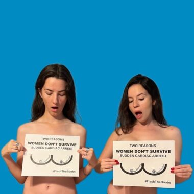 Two unclothed women standing before a blue background cover their breasts with signs that say "Two Reasons Women Don't Survive Sudden Cardiac Arrest."