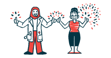 A clinician in a white lab coat with a red head scarf stands next to a person with a red shirt and black pants, both making the thumbs up gesture, with fireworks in the background.